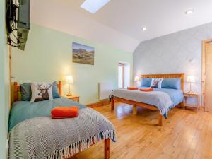 a bedroom with two beds and two tables in it at Quinag Studio Apartment - Uk49098 in Inchnadamph +7 photos