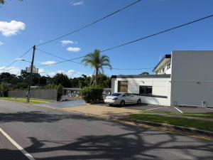 a white car parked in a parking lot next to a building at Aspley Motor Inn in Brisbane