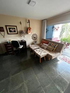 a living room with a couch and a guitar at Studio do Wander in Amparo