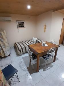 a room with a wooden table and a bed at La Pradera in Tres Picos