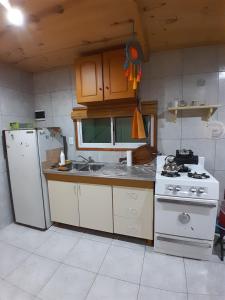 a kitchen with a white refrigerator and a stove at La Pradera in Tres Picos +21 photos