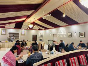 a group of people sitting at tables in a restaurant at Najd Luxury Camp in Wadi Rum