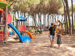 a man and a woman standing in a playground at great mobile home in Cesenatico in Cesenatico