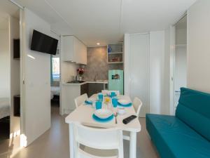 a dining room and kitchen with a white table and chairs at great mobile home in Cesenatico in Cesenatico