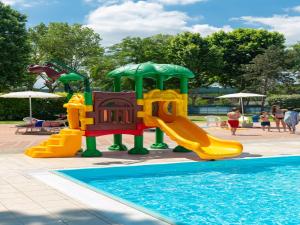 a playground with a slide and a pool at Cozy mobile home in Cesenatico in Cesenatico