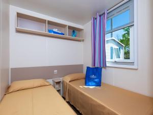 two beds in a room with a window at Cozy mobile home in Cesenatico in Cesenatico +16 photos