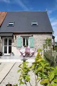 une maison avec une table et des chaises devant elle dans l'établissement Gite du courtils, à Courtils