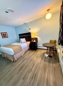a hotel room with a bed and a table at Melville Country Inn in Melville