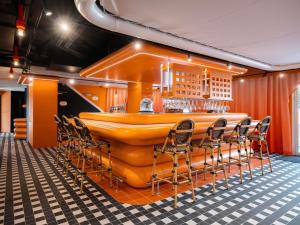 a bar with chairs and a yellow bar at ibis Styles La Rochelle Centre les Minimes in La Rochelle