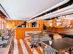 a restaurant with tables and chairs and a bar at ibis Styles La Rochelle Centre les Minimes in La Rochelle