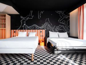 a bedroom with two beds and a black and white checkered floor at ibis Styles La Rochelle Centre les Minimes in La Rochelle +26 photos