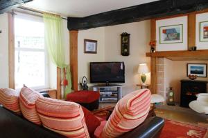 a living room with a couch and a tv at Gite du courtils in Courtils