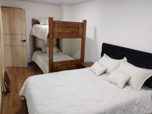 a bedroom with a bed with two bunk beds at Hospedaje Santa Barbara in Tabio