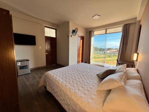a bedroom with a large bed and a large window at La Posada del Pastor in Tarapoto