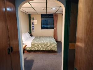 a small room with a bed and a window at Hotel Piquellan in Quito