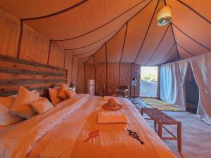 a bedroom with a large bed in a tent at Merzouga heritage camp in Merzouga
