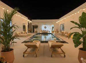 a swimming pool with lounge chairs and a swimming poolvisor at Villa Santoni Mũi Né in Mui Ne