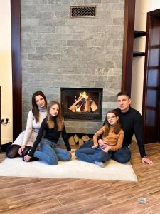 a group of people sitting on the floor in front of a fireplace at City-Top Panorama House & Apartments in Esztergom