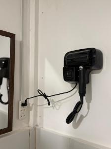 a phone hanging on a wall next to a mirror at Leianna House in Itaytay