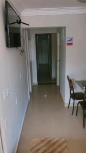 a hallway with a table and a television on a wall at Pousada 705 Norte 2 in Brasília