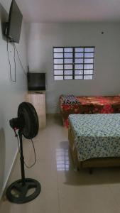a room with two beds and a flat screen tv at Pousada 705 Norte 2 in Brasília