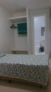 a bedroom with a bed with a blue and white comforter at Pousada 705 Norte 2 in Brasília