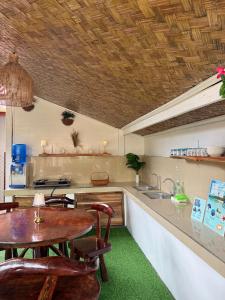 a kitchen with a table and a counter with a sink at Leianna House in Itaytay