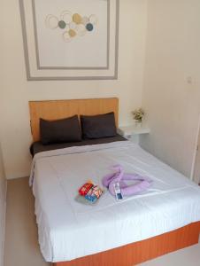 a bed with white sheets and purple towels on it at PONDOK CHILLY in Cirebon +18 photos
