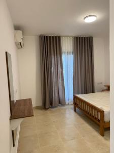 a bedroom with a bed and a large window at Celia new capital 3 bedrooms in Cairo