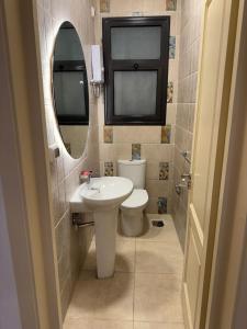 a bathroom with a sink and a toilet and a mirror at Celia new capital 3 bedrooms in Cairo