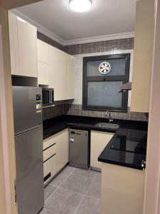 a kitchen with white cabinets and a sink and a window at Celia new capital 3 bedrooms in Cairo