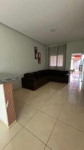 a living room with a couch and a tile floor at Casa familiar no Campestre, tranquila e bem localizada in São Raimundo Nonato