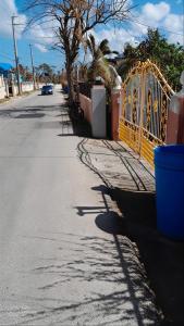 a yellow gate on the side of a street at The cozy spot negril in Negril