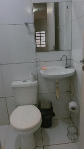a bathroom with a white toilet and a sink at Pousada 705 Norte 3 in Brasília