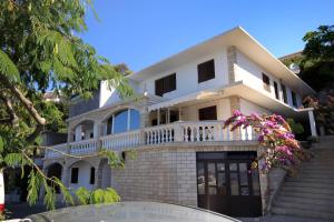 a white house with a balcony and stairs at Apartment Zavalatica 184a in Čara
