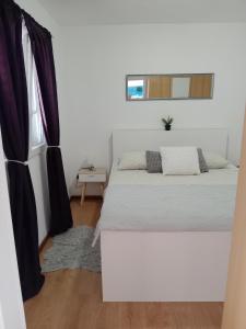 a bedroom with a white bed and a window at Apartment Zavalatica 184a in Čara