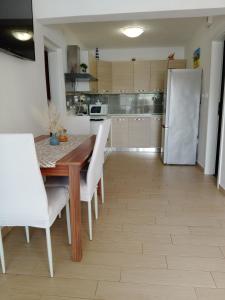 a kitchen with a table and chairs and a refrigerator at Apartment Zavalatica 184a in Čara