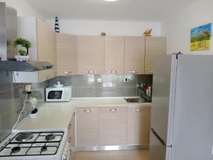 a kitchen with wooden cabinets and a white refrigerator at Apartment Zavalatica 184a in Čara +13 photos