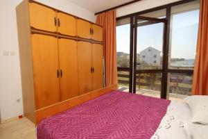 a bedroom with a bed and a large window at Apartment Nevidjane 8401a in Neviđane