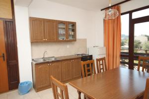 a kitchen with a wooden table and a dining room at Apartment Nevidjane 8401a in Neviđane