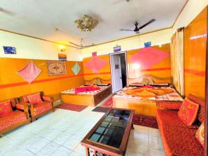 a room with three beds and a table and chairs at Himvadi Resorts Kausani in Kausani