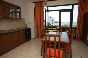 a kitchen with a dining table and a view of the ocean at Apartment Nevidjane 8401a in Neviđane