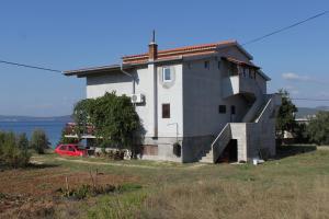 a house on a hill with a red car in front of it at Studio Nevidjane 8401a in Neviđane