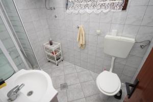 a bathroom with a white toilet and a sink at Studio Nevidjane 8401a in Neviđane