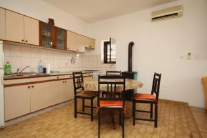 a kitchen with a table and chairs and a stove at Studio Nevidjane 8401a in Neviđane +20 photos