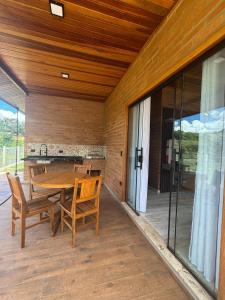 a dining room with a table and chairs on a patio at Vila do Sossego in São Bento do Sapucaí
