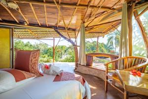 a bedroom with two beds and a table and chairs at Vanira Lodge in Teahupoo