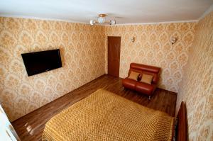 a bedroom with a bed and a tv and a chair at Cozy flat on Pushkin 33 in Chişinău