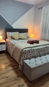 a bedroom with a bed with a couch and two lamps at House in Santa Vitória Do Palmar in Santa Vitória do Palmar
