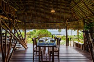 a dining room with a blue table and chairs at Vanira Lodge in Teahupoo